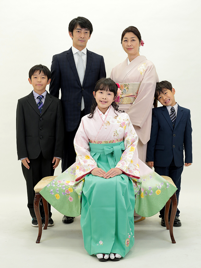 ご家族と一緒に写真を撮る袴姿の小学生
